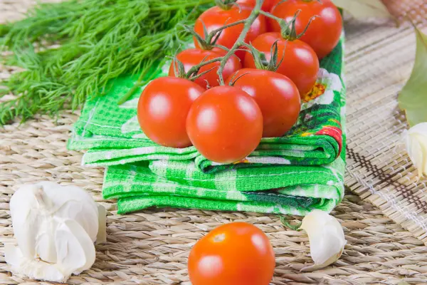 Röda mogna tomater med färsk grönska på en servett — Stockfoto