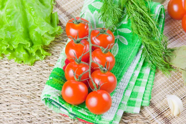 Röda mogna tomater med färsk grönska på en servett — Stockfoto