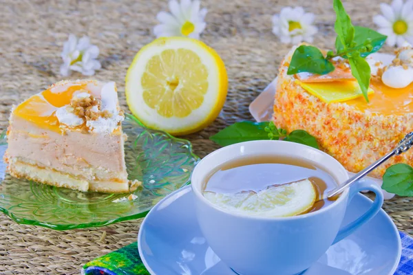 A delicious sweet cake is beautifully decorated and cup of tea w — Stock Photo, Image