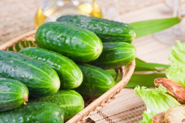 Fresh cucumbers in a ped on a table clipart