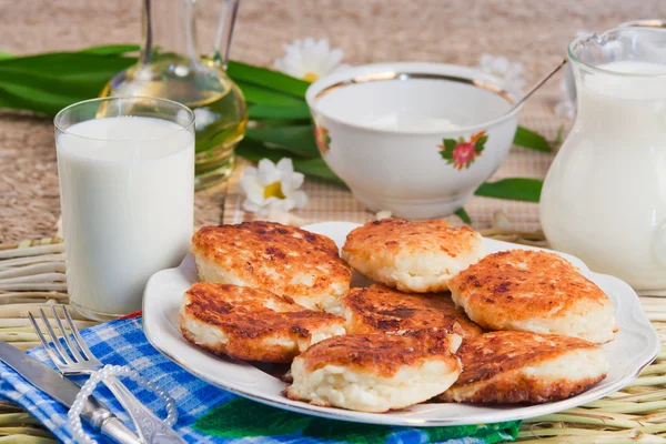 Stekt ostmassa pannkakorna på ett fat och mjölk — Stockfoto