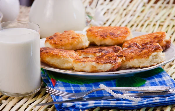 Fried curd pancakes on a dish and milk — Stock Photo, Image