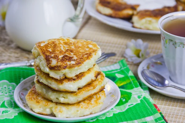 stock image Cup with tea, curd pancakes on a dish and milk