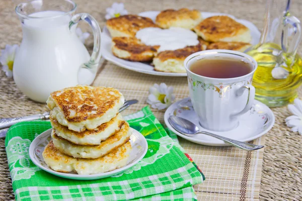 Filiżanka z herbatą, twarogi naleśniki na danie i mleka — Zdjęcie stockowe