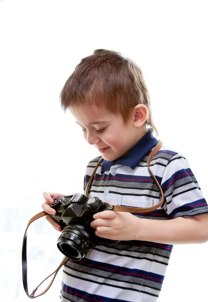 Menino com uma câmera nas mãos sobre um fundo branco — Fotografia de Stock