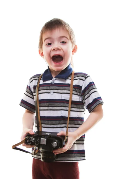 Kleine jongen met een camera in handen op een witte achtergrond — Stockfoto