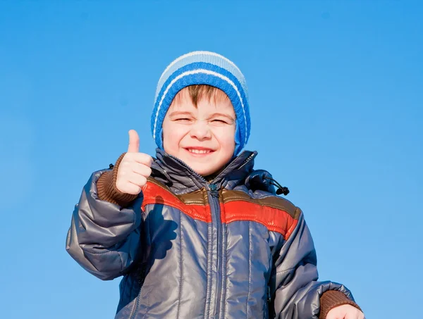Kleine jongen op een achtergrond blauwe hemel — Stockfoto