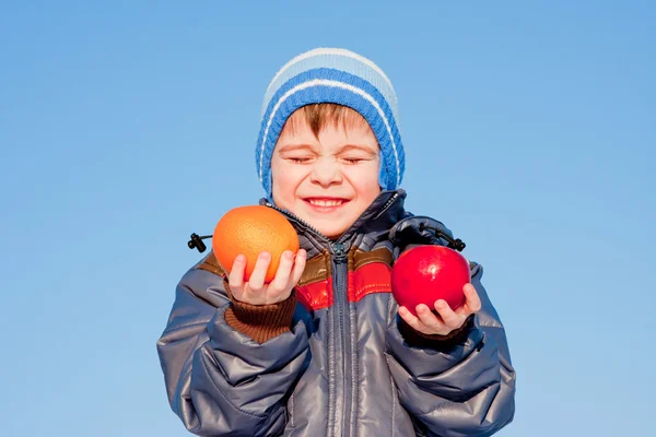Kleine jongen met fruit in handen — Stockfoto