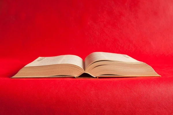 Open book on a bright red background — Stock Photo, Image