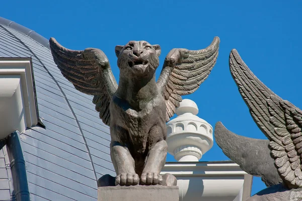Plastiky lvů na střeše budovy na pozadí modré — Stock fotografie