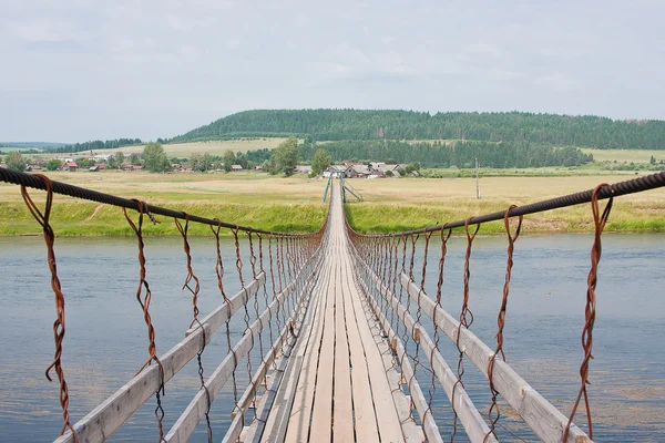 Paisaje rural con el puente colgante — Foto de Stock