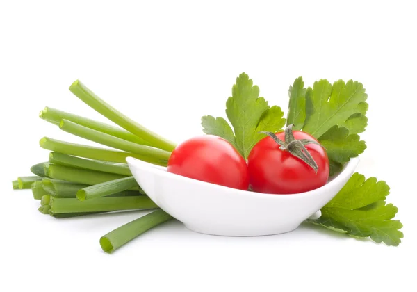 Lente-uitjes en cherry tomaat in kom — Stockfoto
