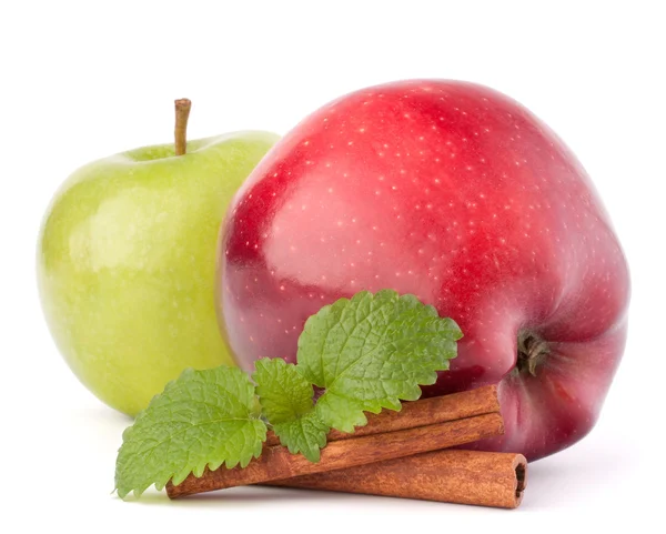 Red and green apples, cinnamon sticks and mint leaves still life — Stock Photo, Image
