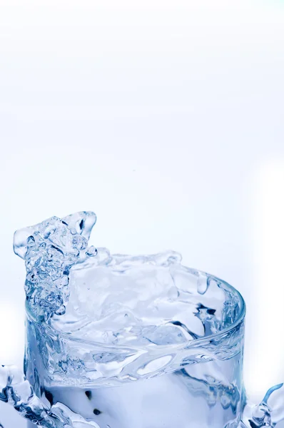 Mineraal water uitspatten van doorschijnend glas — Stockfoto