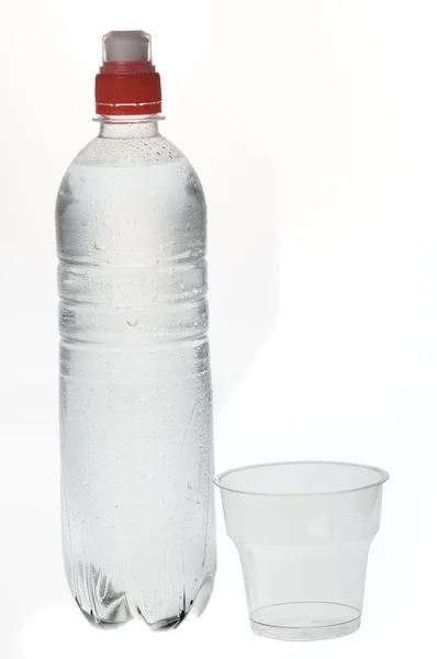 Soda water bottle with plastic glass — Stok fotoğraf
