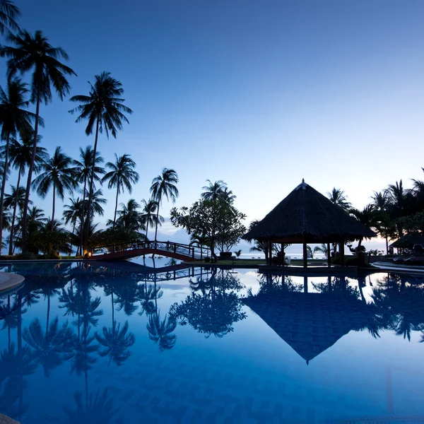Fantastische zonsopgang bij zwembad wit palmen achtergrond — Stockfoto