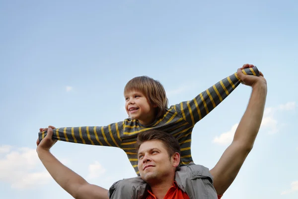 Щасливий син на плечах батька — стокове фото