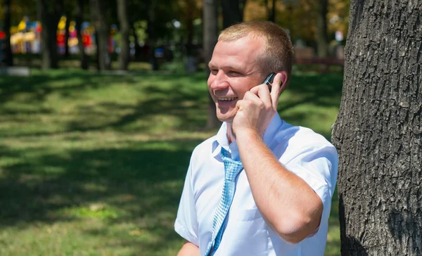 Молодой бизнесмен переговоров по телефону в парке — стоковое фото