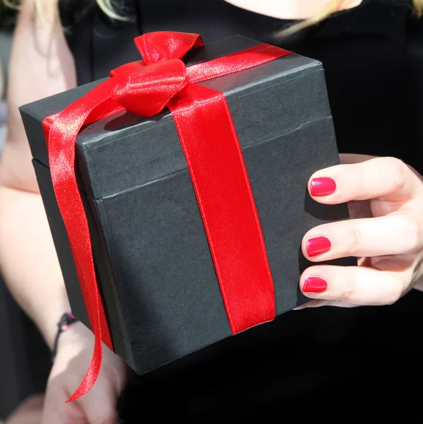 Kvinnliga handen håller en gåva — Stockfoto