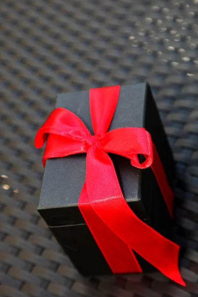 Kırmızı dekoratif fiyonklu hediye paketi — Stok fotoğraf