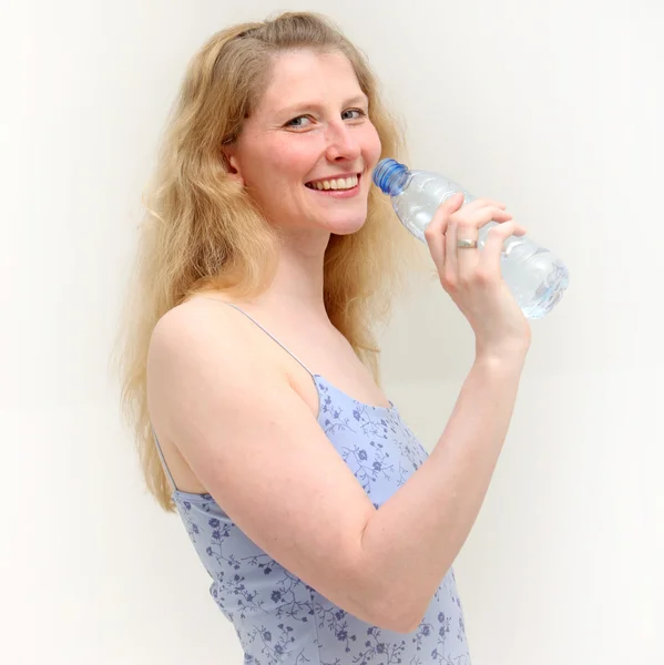 Chica rubia sonríe mientras toma un trago de agua — Foto de Stock