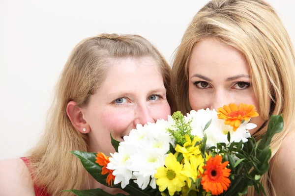 Две блондинки с цветами — стоковое фото