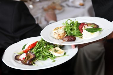 Waiter carrying plates of starters clipart