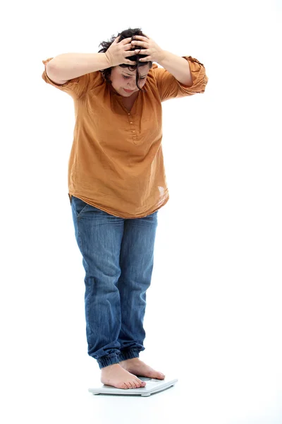 Vrouwen met overgewicht staande op een schaal en is geschokt — Stockfoto