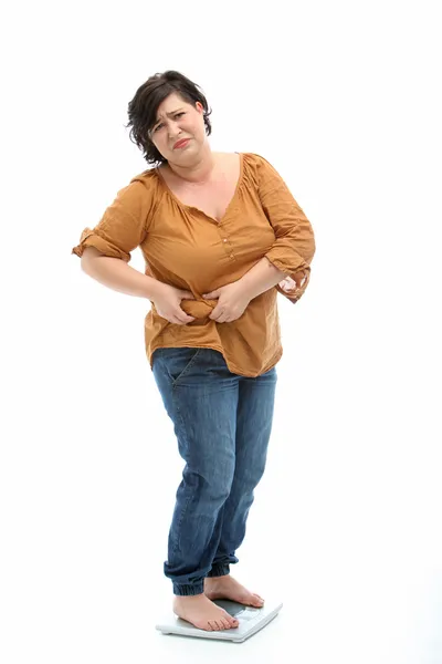 Kobiety z nadwagą stojący na skali i wygląda smutno — Zdjęcie stockowe