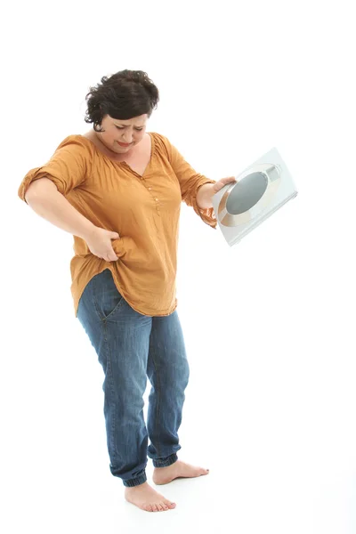 Di nuovo alcuni chilogrammi più - con scala femminile infelice Fotografia Stock
