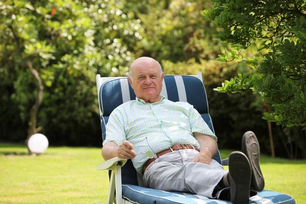 Nyugdíjas ember pihen az árnyékban egy fa — Stock Fotó
