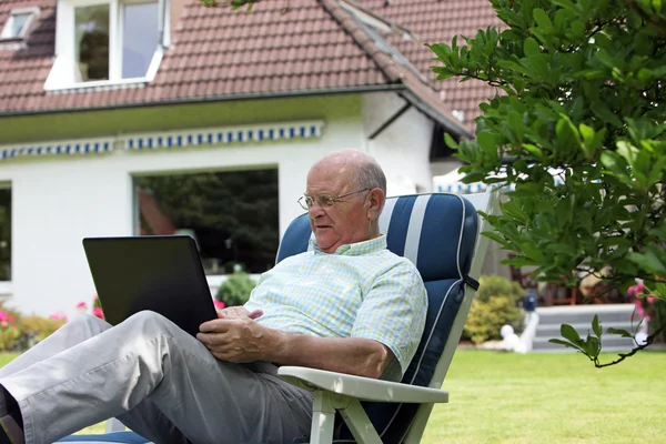 Homme retraité travaillant à l'extérieur sur un ordinateur portable — Photo