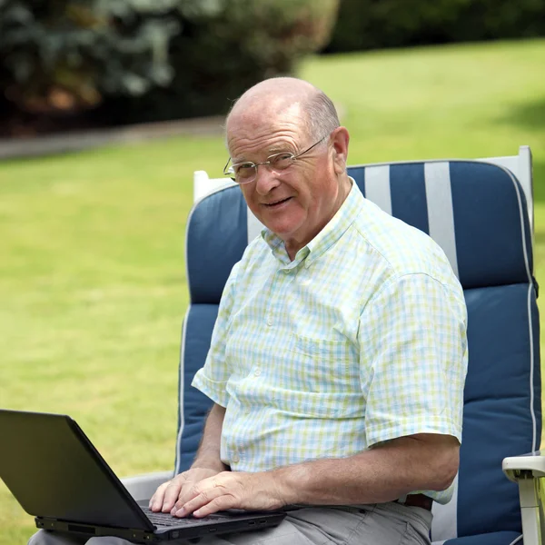Старший человек печатает на ноутбуке — стоковое фото