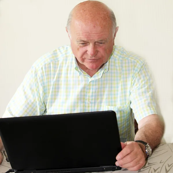 Pensionista de edad avanzada usando una computadora portátil — Foto de Stock