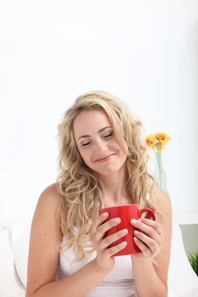Vrouw in bed met koffie — Stockfoto