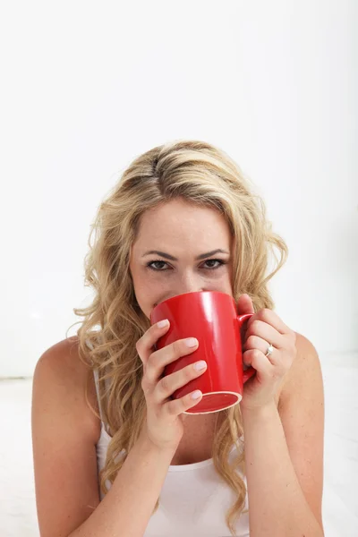 目のコーヒーを飲むを笑顔で女性 ロイヤリティフリーのストック画像