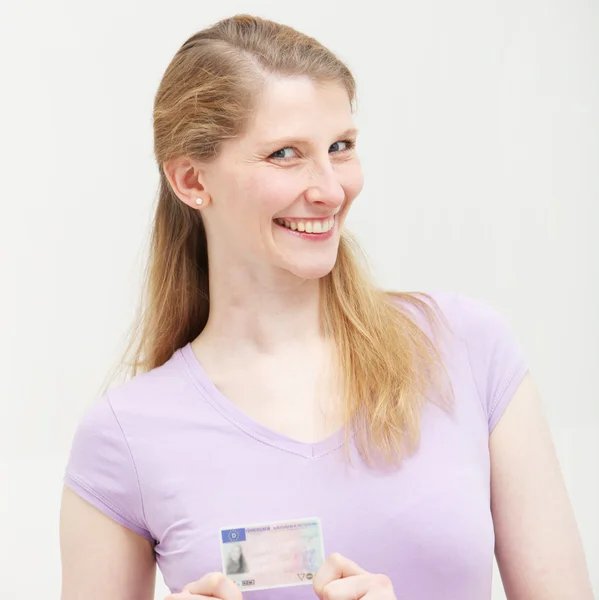 मुस्कुराते सुनहरे बालों वाली महिला अपने आईडी कार्ड के साथ स्टॉक इमेज