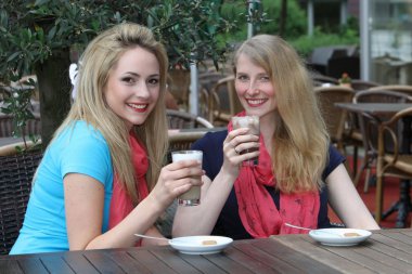 Female friends enjoying iced coffee clipart