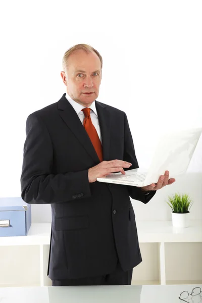 Executivo sênior trabalhando em seu laptop — Fotografia de Stock