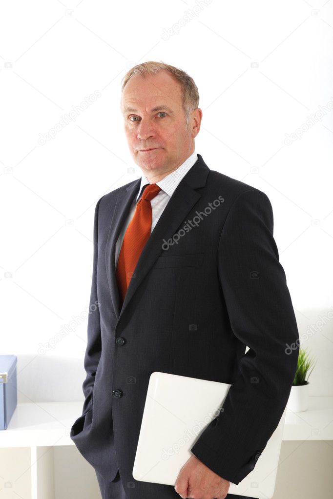 Company director standing with laptop