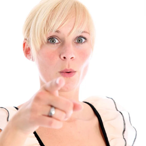 Shocked young woman pointing at camera — Stock Photo, Image
