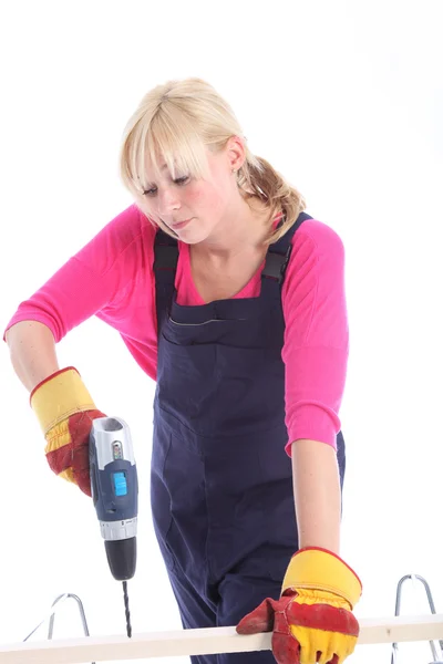 Woman drilling a hole in a plank of wood — Stock Photo, Image