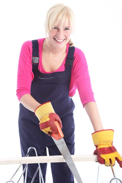 Mujer feliz cortando madera con una sierra de mano — Foto de Stock