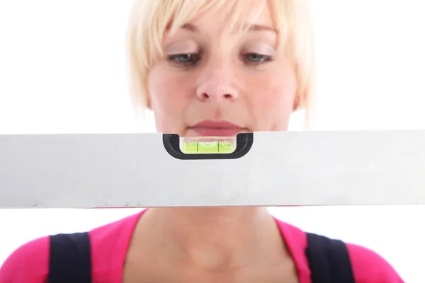 Woman looking at a spirit level — Stock Photo, Image