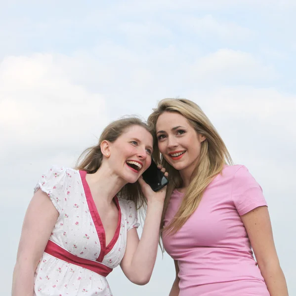 Duas mulheres ouvindo um telefonema — Fotografia de Stock