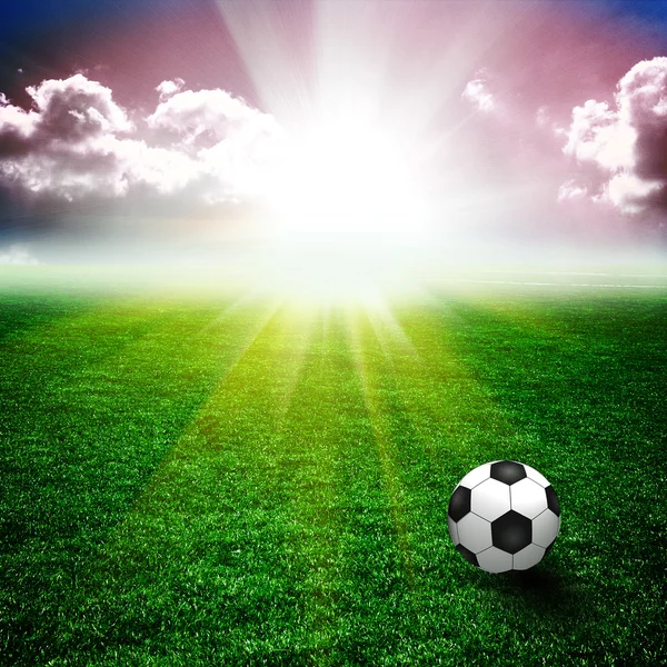 A fine green meadow with a soccer ball on it. All on sky sunset — Stock Photo, Image