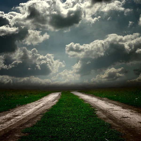 Vägen i fältet med stormigt moln — Stockfoto