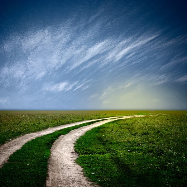 Cesta v poli s mraky — Stock fotografie