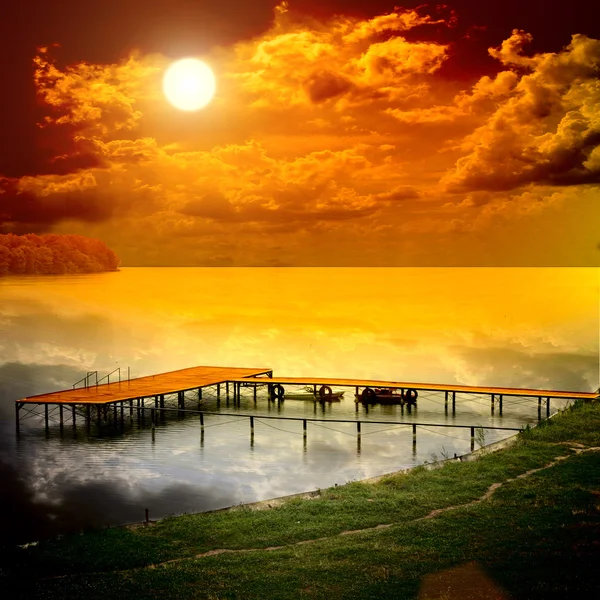 船站上与太阳集美丽的湖 免版税图库图片