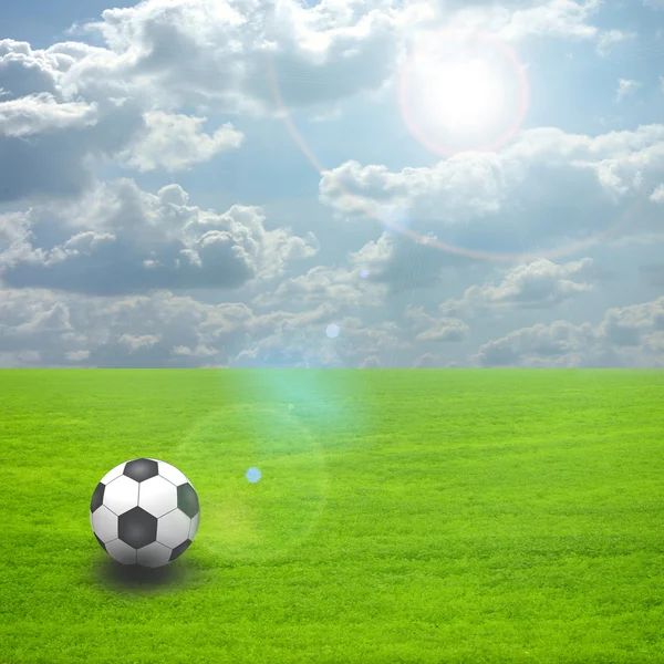 Soccer ball on the green field with sun set — Stock Photo, Image